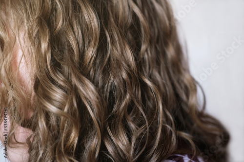 teenage girl with healthy natural wavy hair. blond girl, back view. natural curly no brush method for beautiful stylish look.