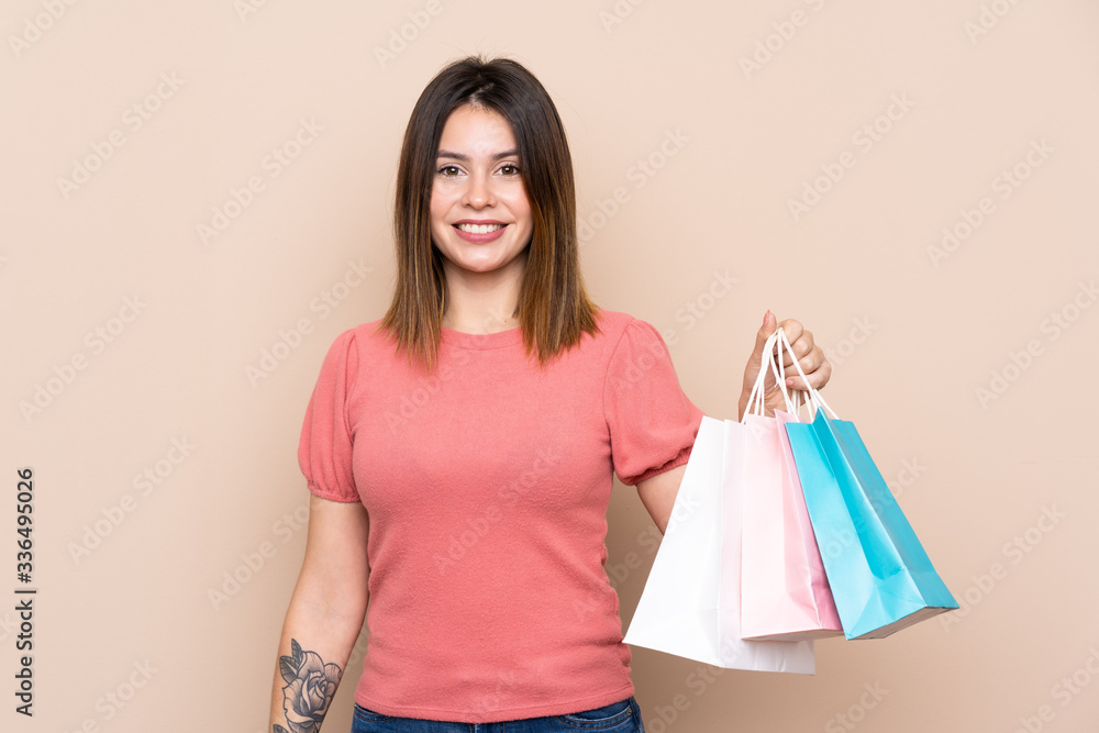 Young woman with shopping bag over isolated background smiling a lot Young woman with shopping bag over isolated background smiling a lot