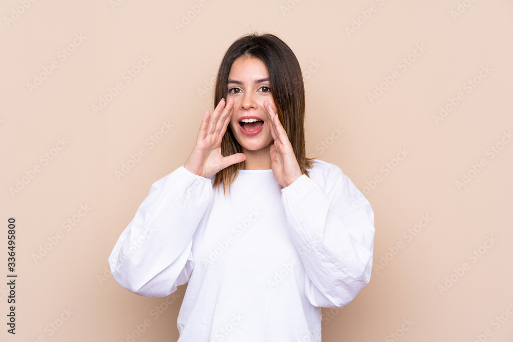 Young woman over isolated background shouting with mouth wide open Young woman over isolated background shouting with mouth wide open