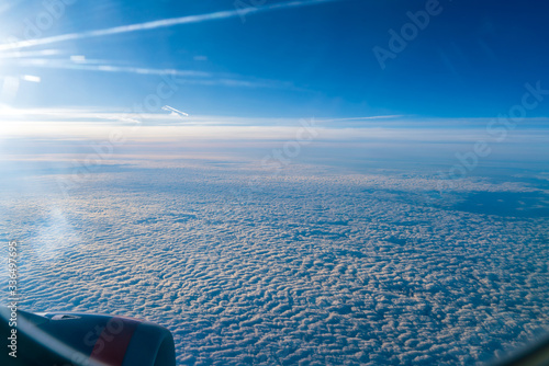The bright sun shining in the window of an airplane