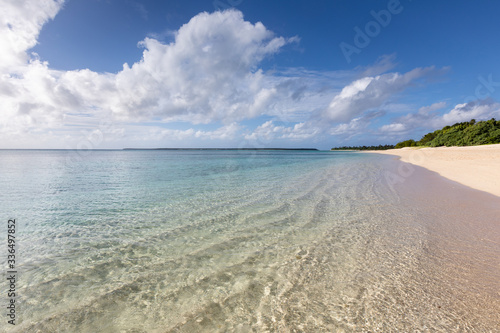 Idyllic sandy beach paradise blue lagoon transparent water fresh green trees no people sunny windless weather South Pacific Ocean Tonga Ha'apai islands photo