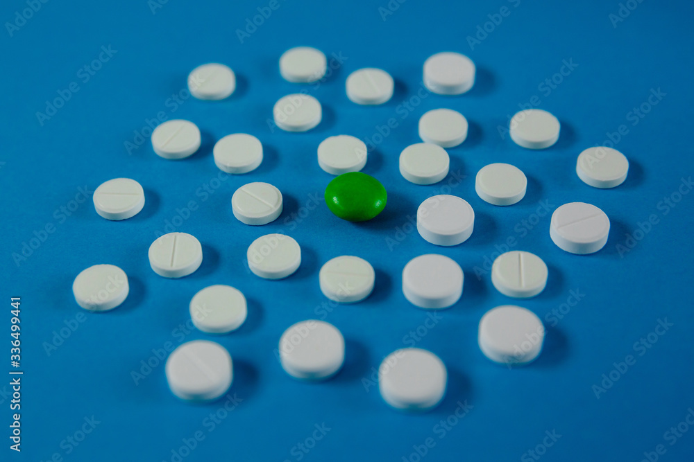many white pills and one red on a blue background many white pills and one red on a blue background