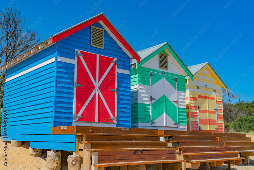 Steps leading to doors of colourful Brighton Beach Boxes on beach at Melbourne.