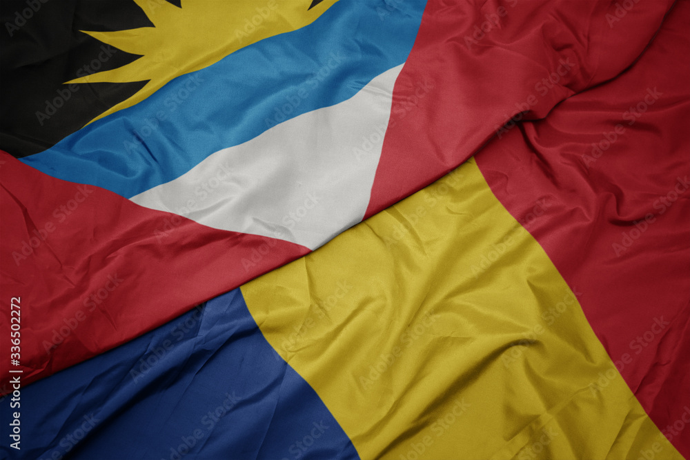 waving colorful flag of romania and national flag of antigua and barbuda.