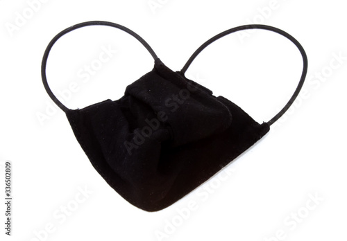black medical mask folded in the form of a heart on a white background