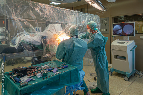 in an operating theatre a patient with a fractured thigh is operated on by doctors
