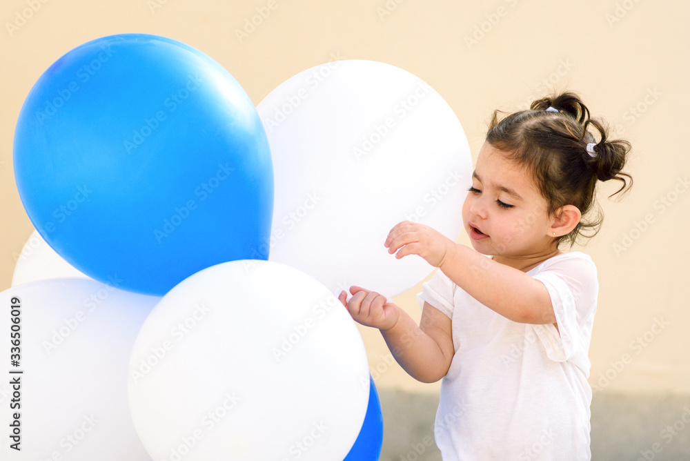 Beautiful small girl with blue and white balloons. Birthday party, happy day concept. Beautiful small girl with blue and white balloons. Birthday party, happy day concept.