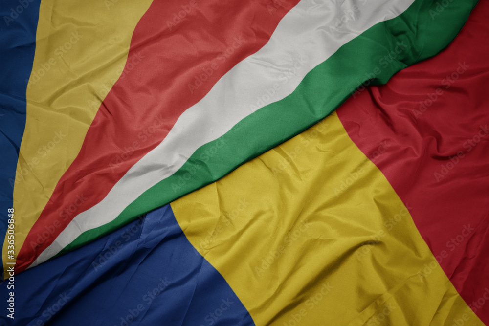 waving colorful flag of romania and national flag of seychelles.