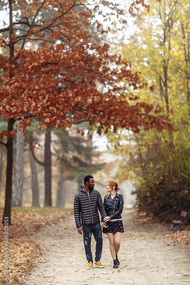 Happy interracial couple walking in autumn park Happy interracial couple walking in autumn park