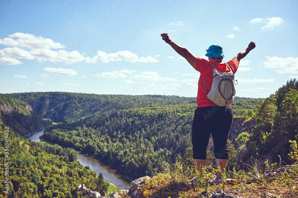 The plump woman raised her hands up, rejoicing ascent to the mountain. The concept of victory over oneself, motivation, strength of character. A beautiful bird's-eye view of a mountain river The plump woman raised her hands up, rejoicing ascent to the mountain. The concept of victory over oneself, motivation, strength of character. A beautiful bird's-eye view of a mountain river