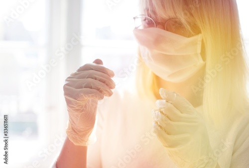 Woman with face mask, gloves. Woman in protective mask wearing rubber gloves. Woman wears a face mask that protects against the coronavirus. Close- up of a woman with a mask against SARS-cov-2.