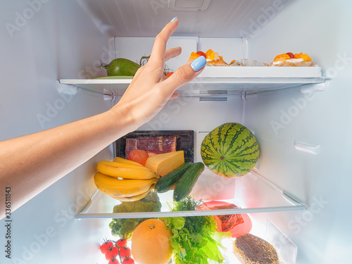 Obraz na płótnie Woman hand picking something from a full open fridge w salonie