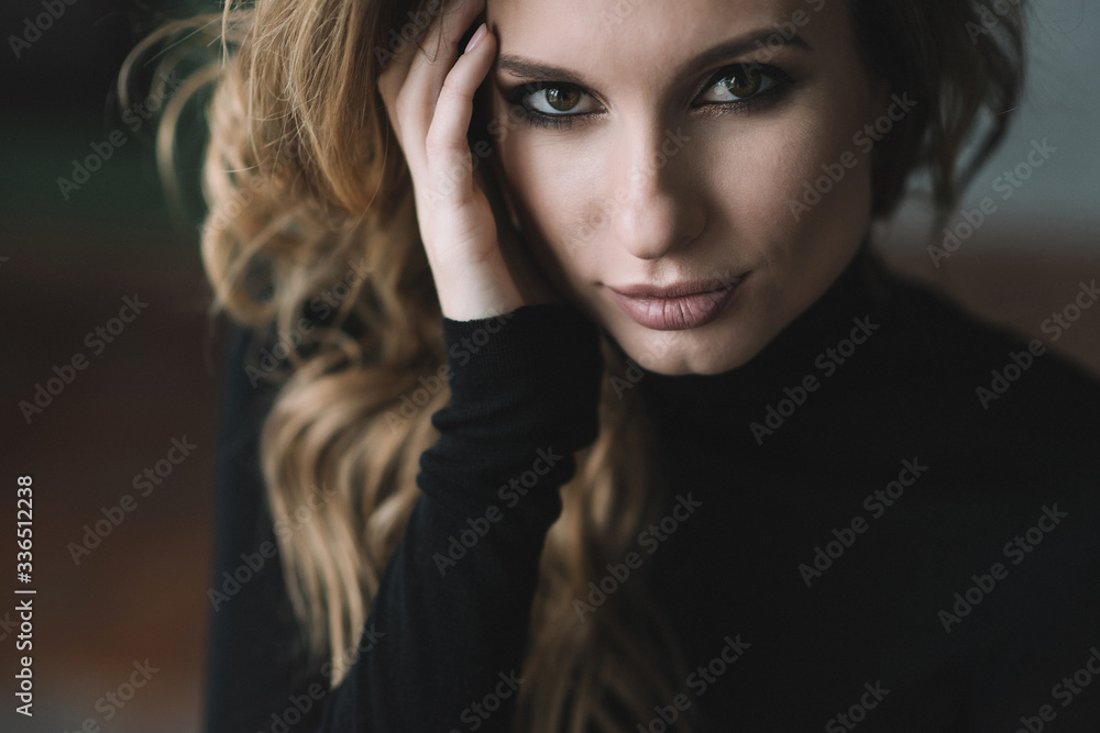 Beautiful woman with curls and full lips in a black turtleneck. Close-up portrait. Soft selective focus. Beautiful woman with curls and full lips in a black turtleneck. Close-up portrait. Soft selective focus.