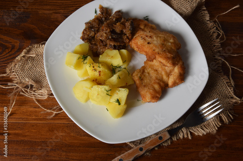 breaded chicken breast with boiled potatoes and fried cabbage