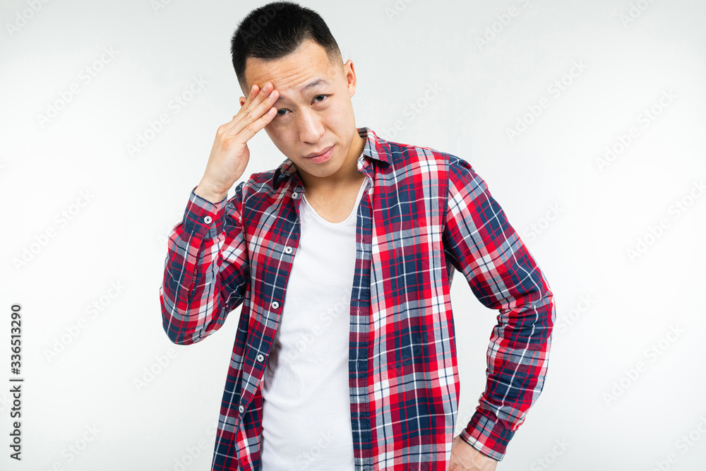 Confident Asian man in a plaid shirt wide open on a white studio background with copy space Confident Asian man in a plaid shirt wide open on a white studio background with copy space