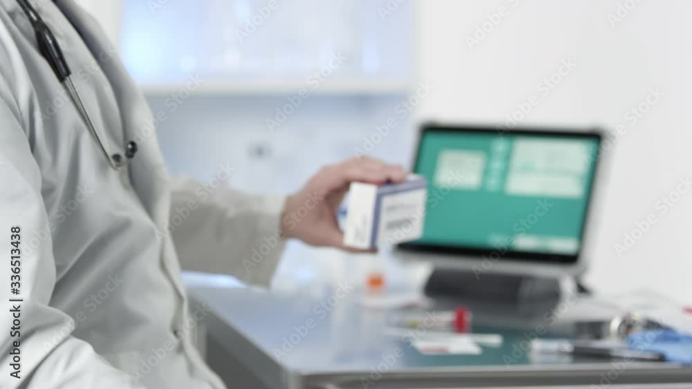Doctor picking up and holding Covid-19 test kit in medical lab. Doctor picking up and holding Covid-19 test kit in medical lab.