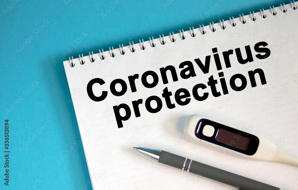 Obraz premium CORONAVIRUS PROTECTION - text on a notepad. Lie a pen and a medical thermometer