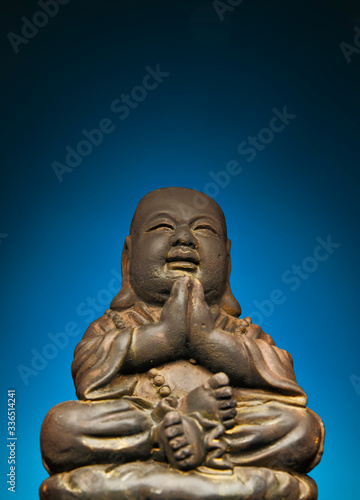 A small replica statue of The Buddha with a blue background, blue symbolizing immortality and advancement. Blue also represents the season of Spring
