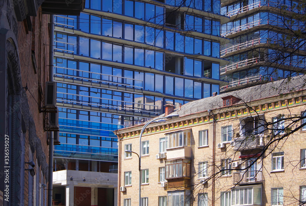 Modern glass buildings next to old brick houses. Kiev. Ukraine.