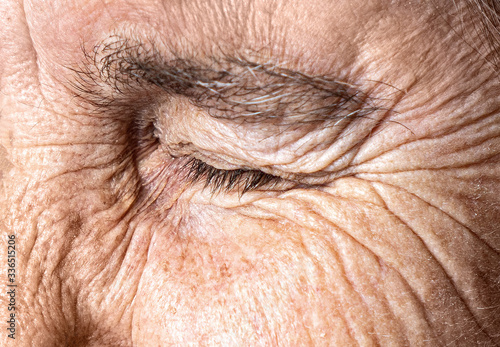 Old age concept. Close-up eye of an elderly woman with a wrinkled face.