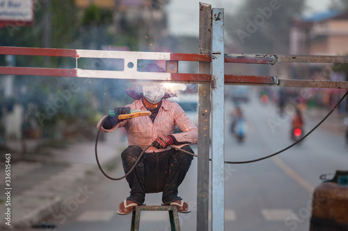 Welding on the street. Road protection maintenance in Cambodia photo