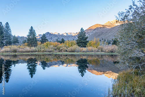 Canvas-taulu early morning lake with mirrored reflection of mountains