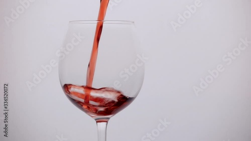 pours wine into a glass in slow motion