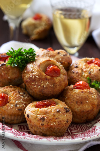 Muffins with cheese, cottage cheese and tomatoes, vegetables and cheese served with wine.