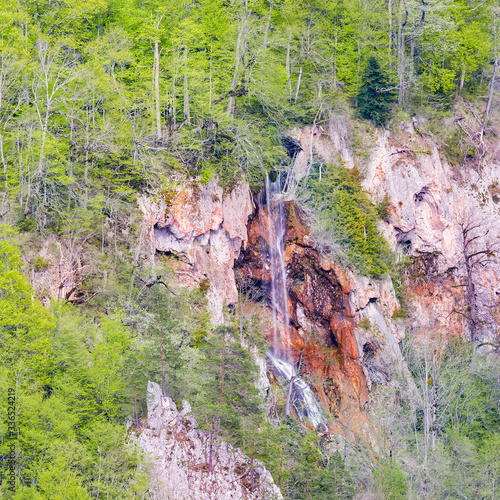 Waterfall on the one side of the deep gorge. Caucasus. Russia. photo