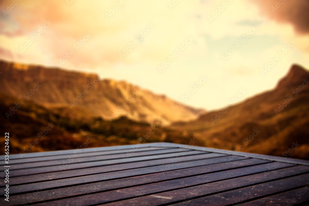 Wooden table of free space for your decoration and blurred landscape of summer mountains. 