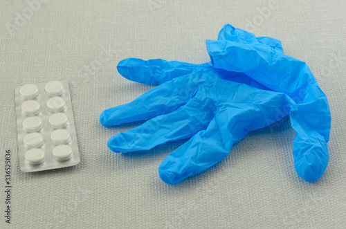 Medical glove and plate of pills, concept of health and infection protection.