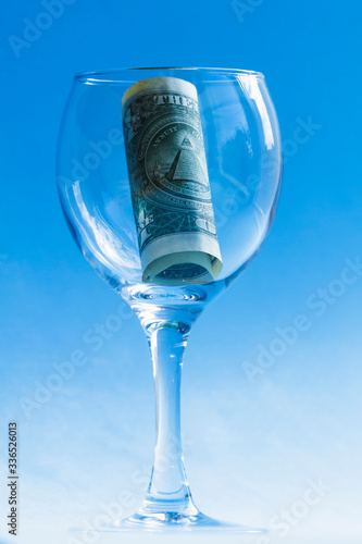American dollar in a beautiful glass on a blue background.