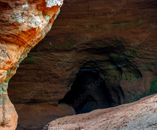 Fototapeta Naklejka Na Ścianę i Meble -  The entrance to the cave, formed many years ago, in sedimentary rocks