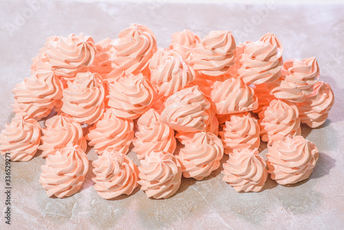 Delicious pink freshly made meringues laid out on a concrete background. Sweet food.