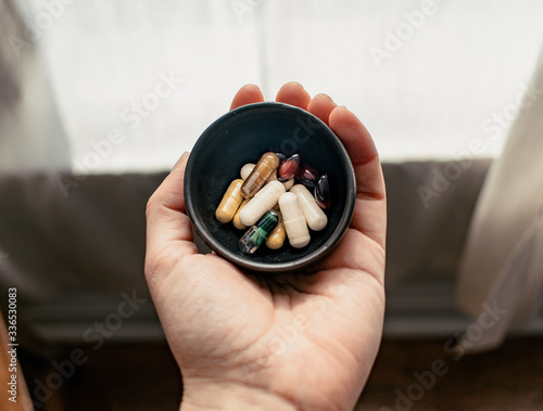 Hand holding bowl of supplements