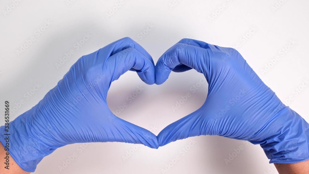 Fototapeta premium Hands of a doctor or nurse in medical gloves depict a heart on a white background, caring doctor and medicine concept