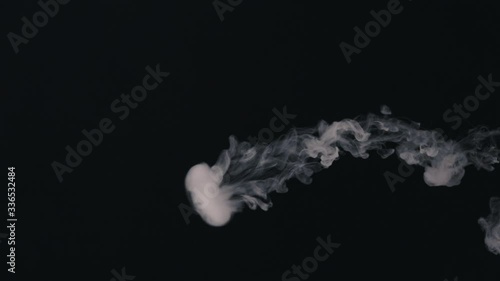 blows smoke rings on a black background