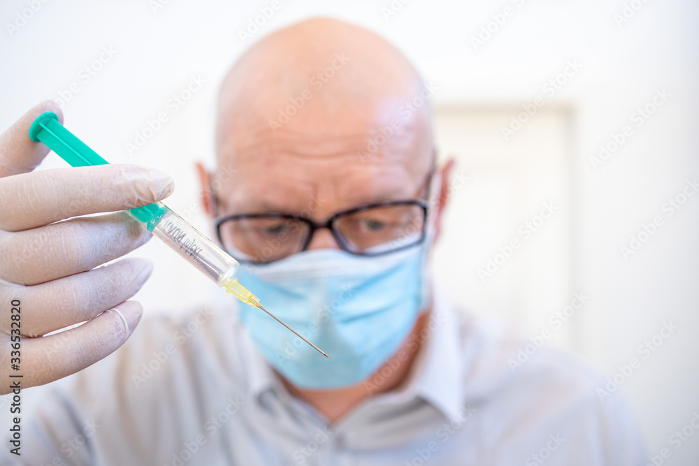 Leipzig, Germany, 07-04-2020 a doctor with an injection syringe and a face mask Leipzig, Germany, 07-04-2020 a doctor with an injection syringe and a face mask