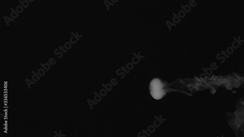 blows smoke rings on a black background
