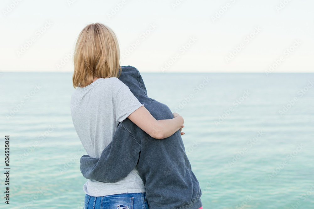 Mutual understanding between the parent and the child. Mother and daughter teenager embrace on the seashore, ocean. Mutual understanding between the parent and the child. Mother and daughter teenager embrace on the seashore, ocean.
