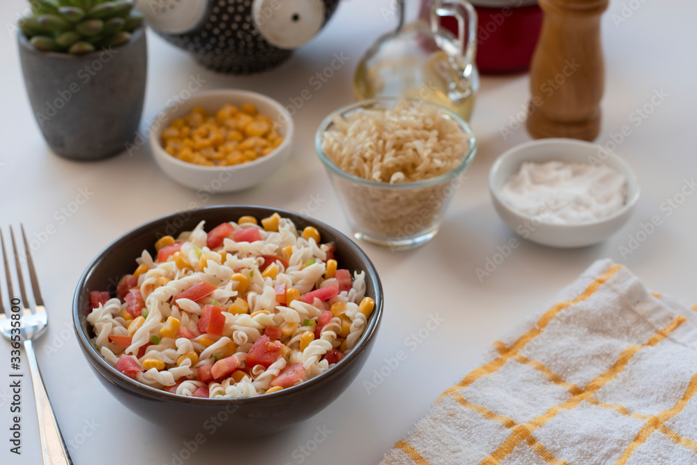 Pasta salad with yogurt and tomato sauce, corn and green onion on white background Pasta salad with yogurt and tomato sauce, corn and green onion on white background