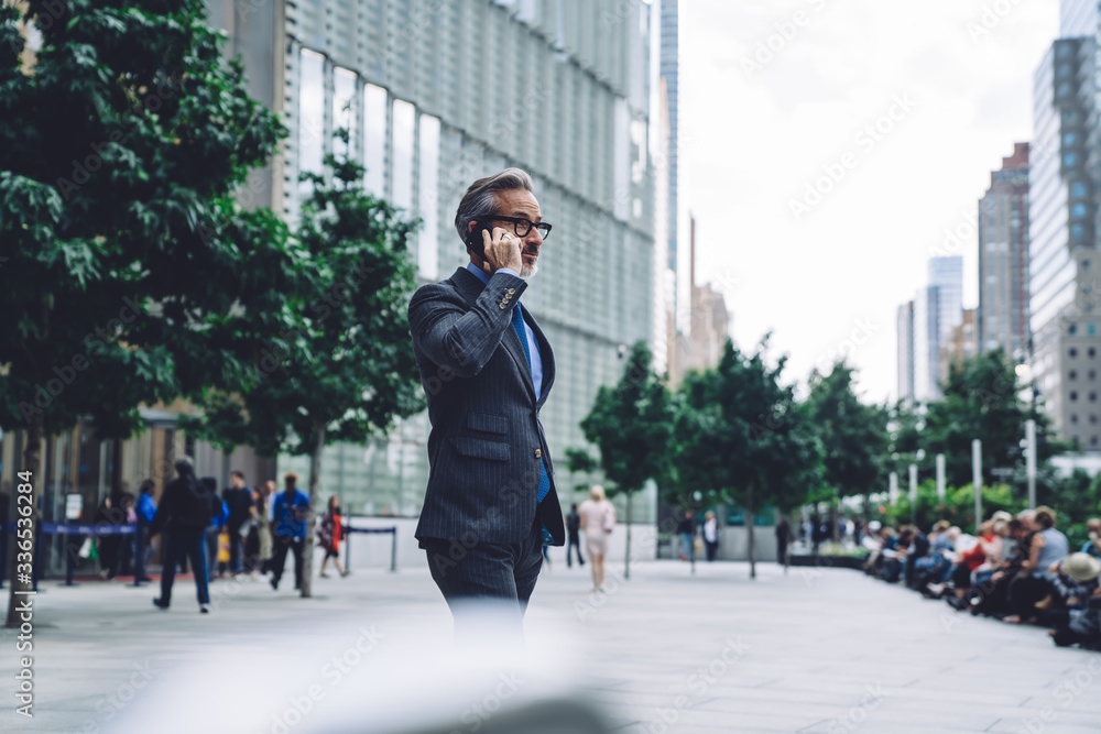 Mature businessman calling by smartphone in city Mature businessman calling by smartphone in city