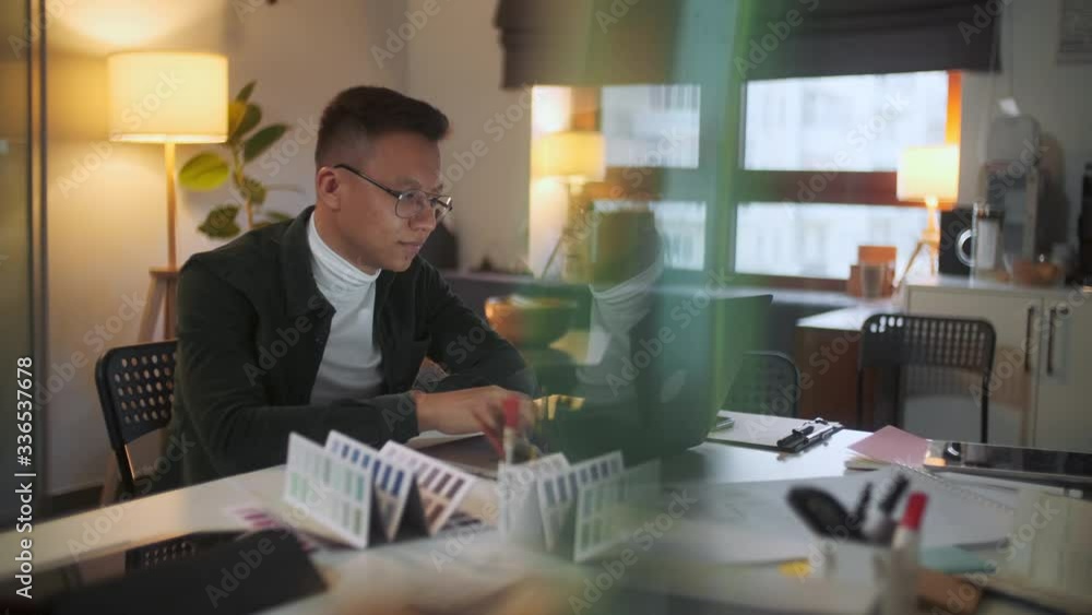 Portrait Of a Man Is Working On Laptop Computer With Glasses At Night. Businessman Working Late At Day Looking At Monitor, Reflections In Glasses, Male Stock Market Trader Using Laptop At Office. Portrait Of a Man Is Working On Laptop Computer With Glasses At Night. Businessman Working Late At Day Looking At Monitor, Reflections In Glasses, Male Stock Market Trader Using Laptop At Office.