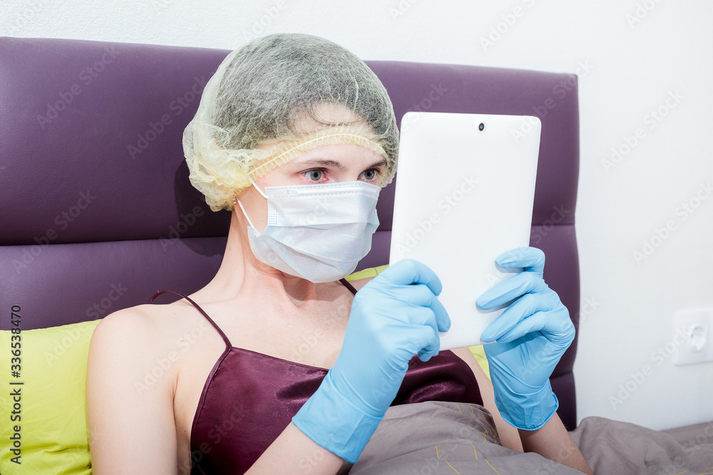 self-isolation and work at home with covid-19 coronavirus. a girl in protective gloves, a mask and a cap on her hair. New reality. Normal life and work in isolation