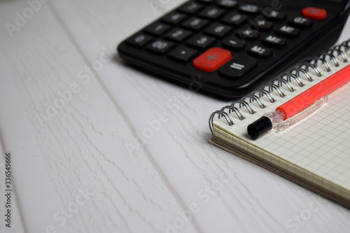 Calculator and a book isolated on office desk. Finance or business concept