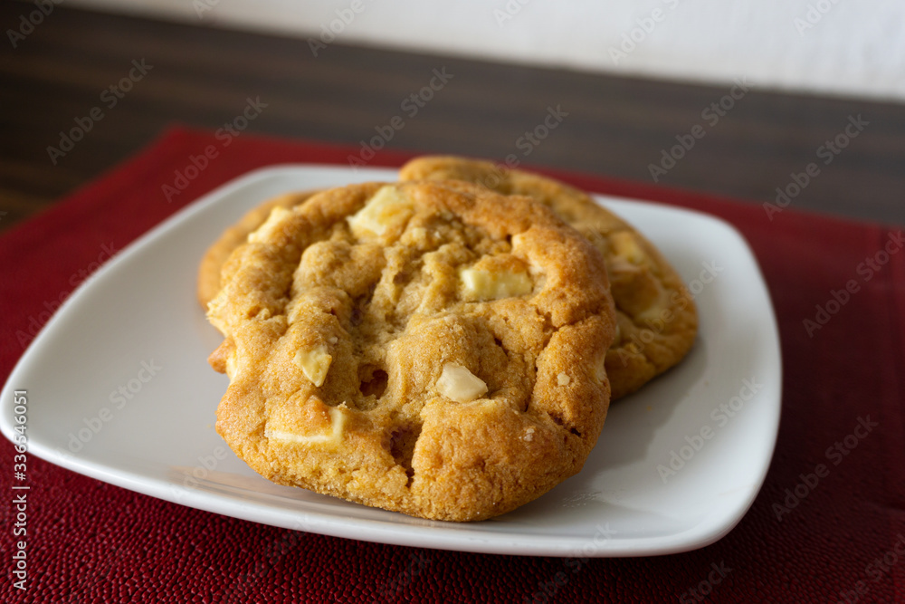 Tasty macadamia and white chocolate cookies on a plate