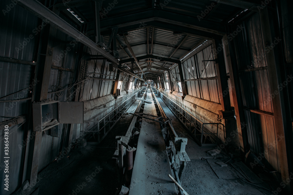 Abandoned cement and concrete factory. Old rusty conveyor in corridor Abandoned cement and concrete factory. Old rusty conveyor in corridor