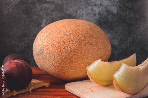 Melon on wooden table with black background
