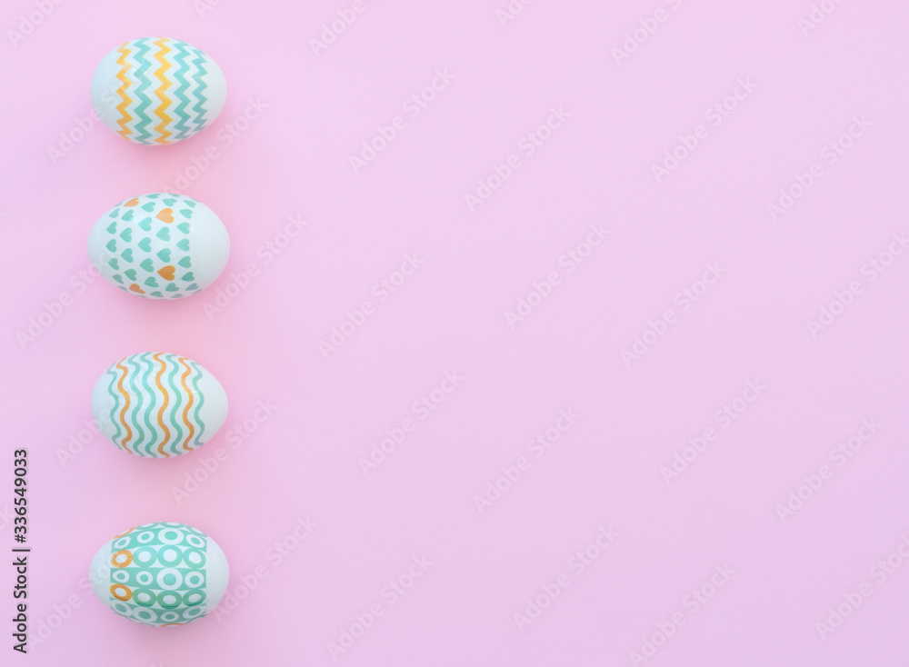 Decorated Easter eggs lie on the pink background. Happy Easter holiday concept. Greeting, invitation card. Flat lay style with copy space.