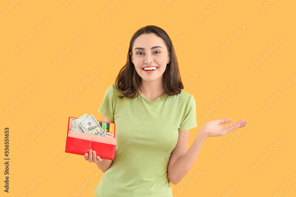 Young woman with wallet on color background
